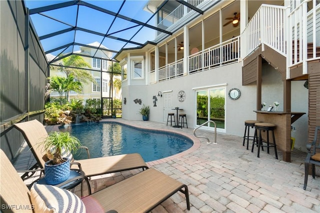 pool with ceiling fan, a lanai, a patio area, and outdoor dry bar