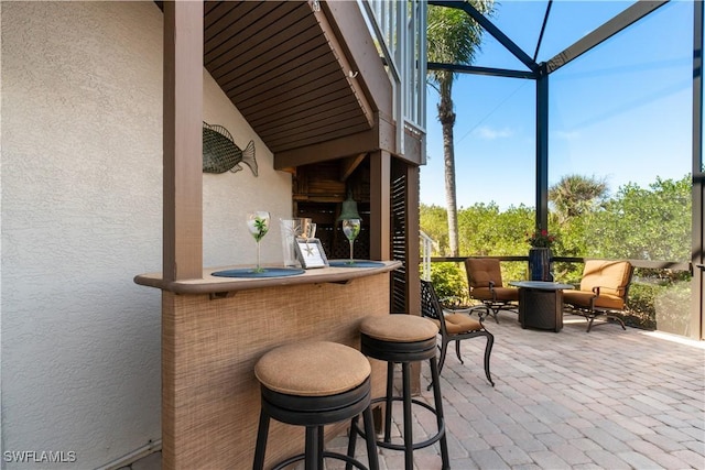 view of patio with glass enclosure and outdoor dry bar