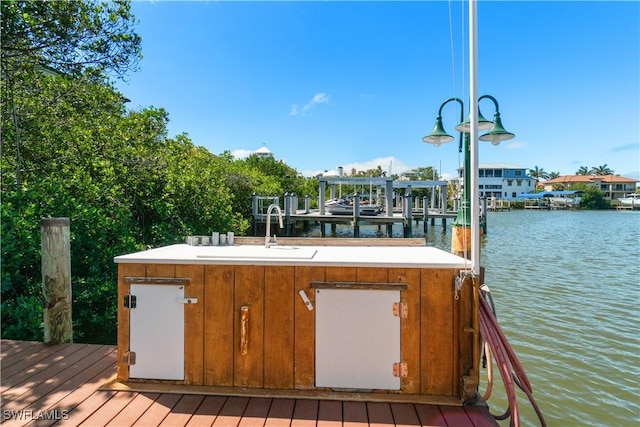 dock area featuring boat lift, a water view, and a sink