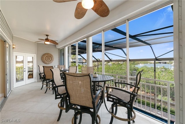 sunroom / solarium with french doors, a water view, and ceiling fan