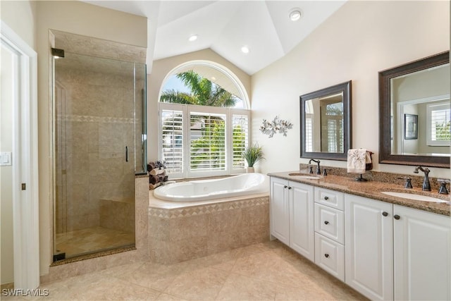 full bathroom featuring vaulted ceiling, a garden tub, a stall shower, and a sink