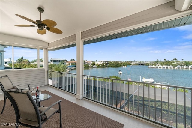 sunroom with a water view and ceiling fan