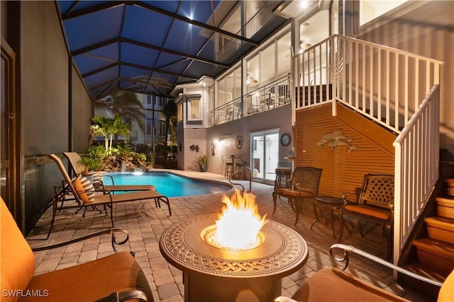 pool with a patio area, a lanai, and a fire pit