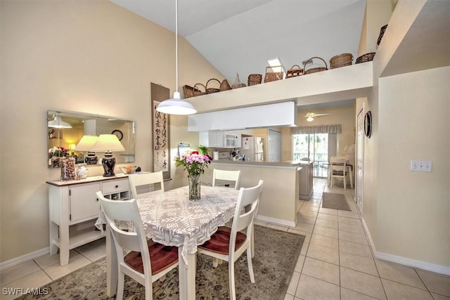 dining space featuring high vaulted ceiling, light tile patterned flooring, a ceiling fan, and baseboards