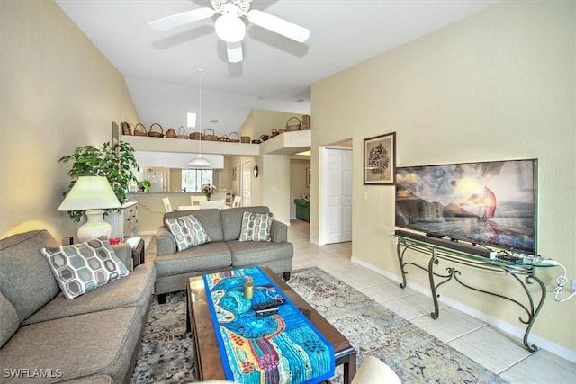 tiled living room featuring baseboards, vaulted ceiling, and a ceiling fan