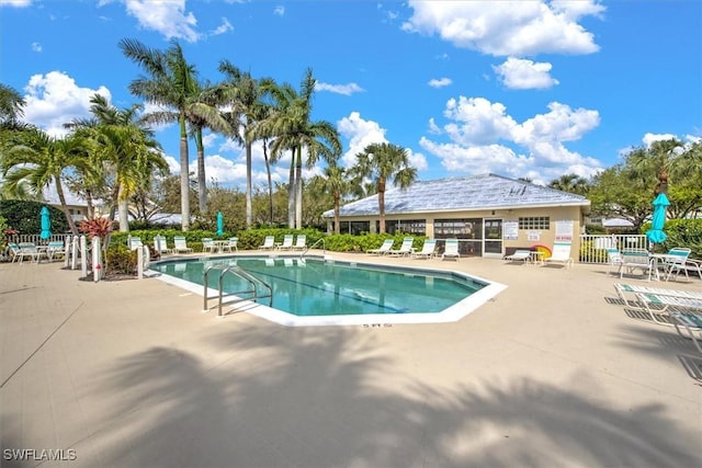 pool with a patio and fence