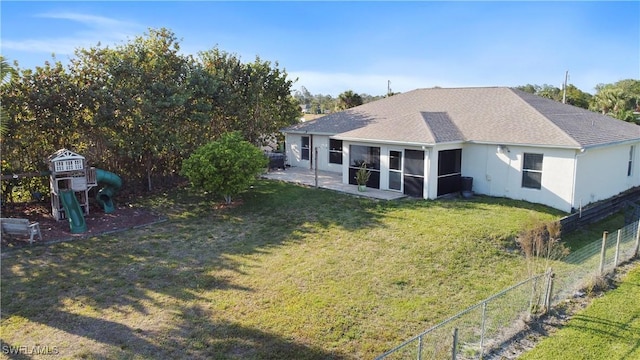 back of property with a playground, fence, a sunroom, a yard, and roof with shingles