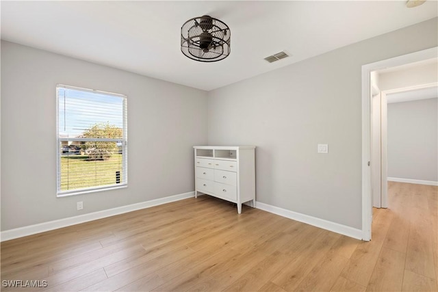 unfurnished bedroom with visible vents, light wood finished floors, and baseboards