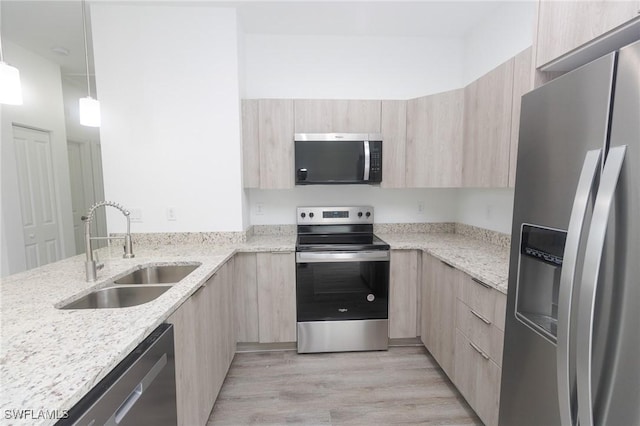 kitchen with a sink, stainless steel appliances, modern cabinets, and light brown cabinets