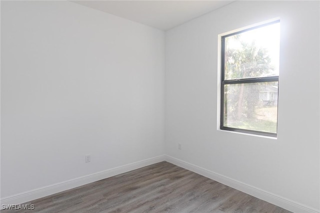 spare room with wood finished floors and baseboards