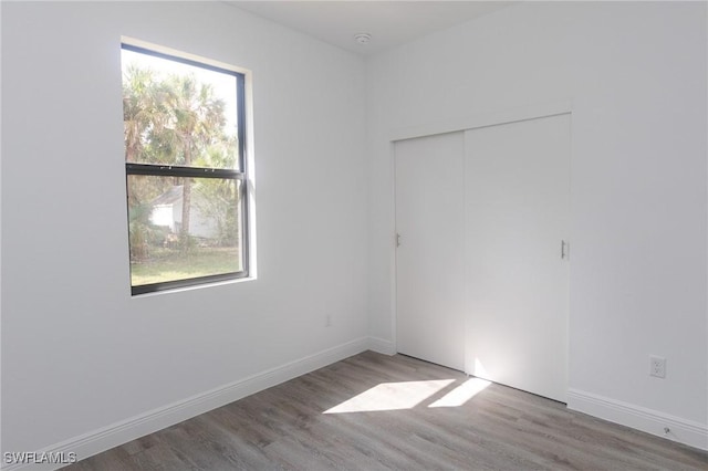 unfurnished room featuring baseboards and wood finished floors