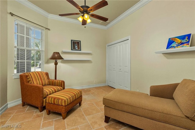 sitting room with ornamental molding, stone tile flooring, and baseboards