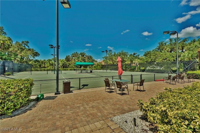 surrounding community with a tennis court and fence