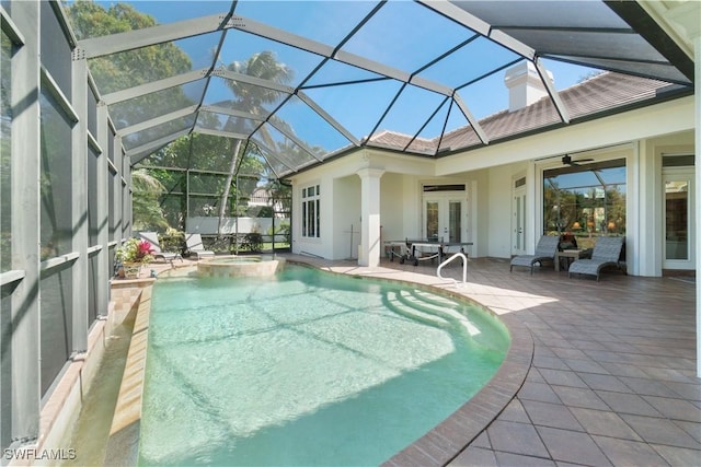 view of pool featuring a pool with connected hot tub, a lanai, french doors, a patio area, and a ceiling fan