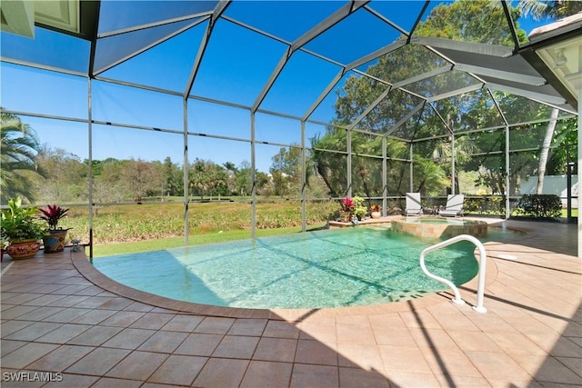 view of pool with glass enclosure, a patio area, and a pool with connected hot tub