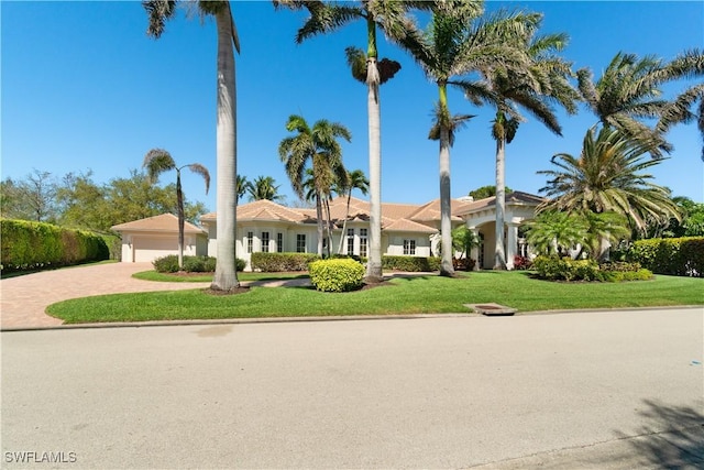 view of front of house featuring a garage, decorative driveway, and a front yard