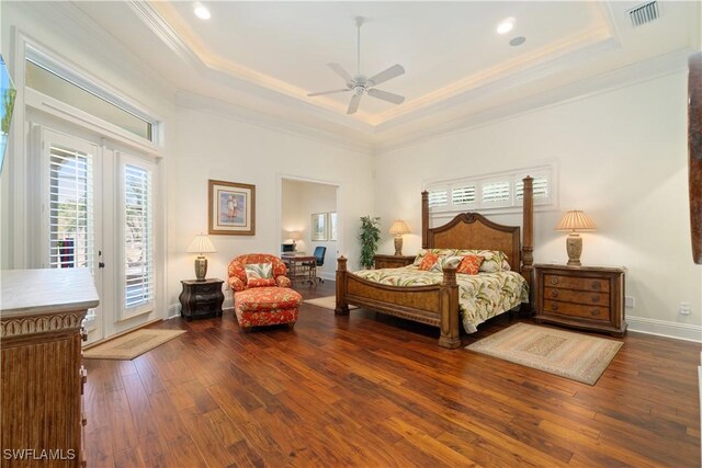 bedroom featuring access to exterior, visible vents, a raised ceiling, and hardwood / wood-style flooring