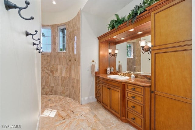 full bathroom featuring vanity, baseboards, and walk in shower