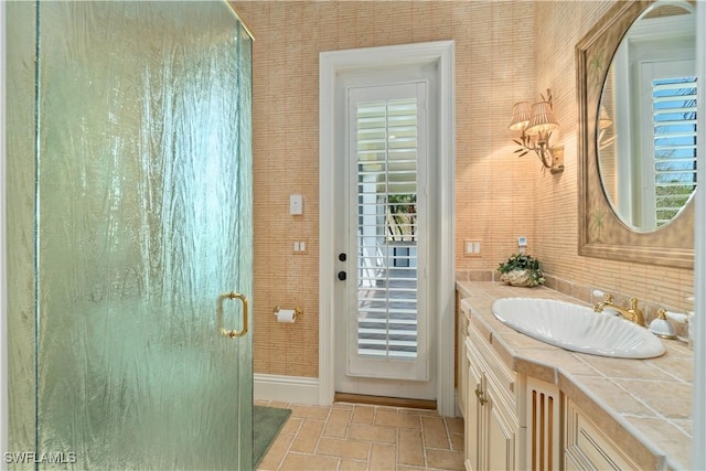 full bath with brick floor, baseboards, a shower stall, and vanity