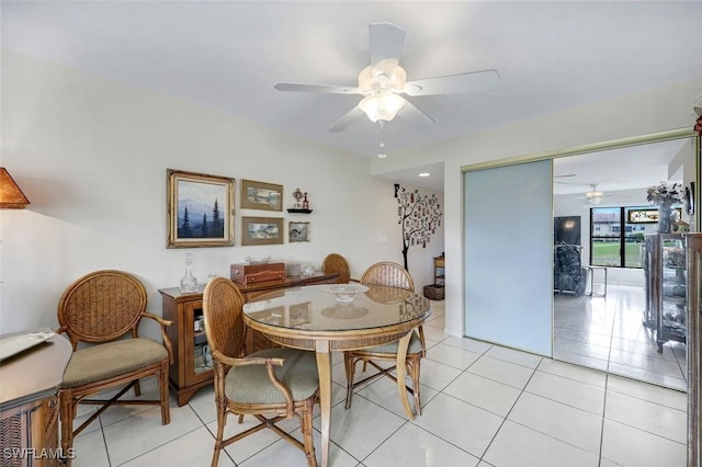 dining space with a ceiling fan and light tile patterned flooring