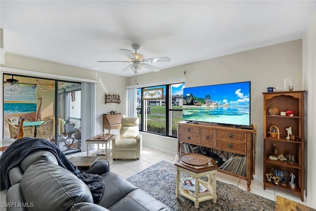 living room with light tile patterned floors, baseboards, and a ceiling fan