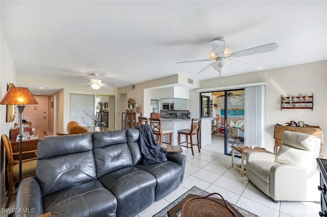 living room with light tile patterned floors, ceiling fan, and visible vents