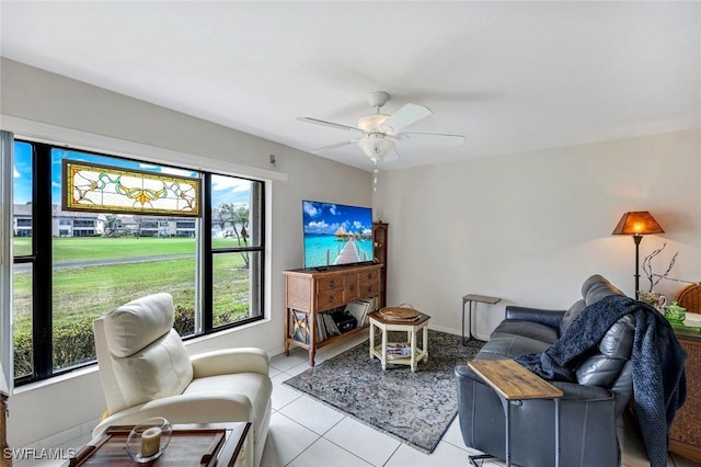 living room featuring light tile patterned floors, ceiling fan, and baseboards