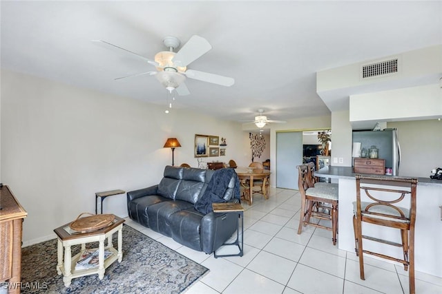 living area featuring ceiling fan, light tile patterned flooring, and visible vents