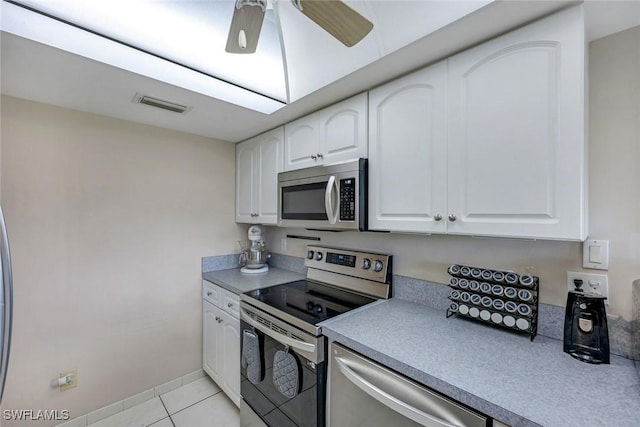 kitchen with light tile patterned flooring, stainless steel appliances, a ceiling fan, visible vents, and white cabinets