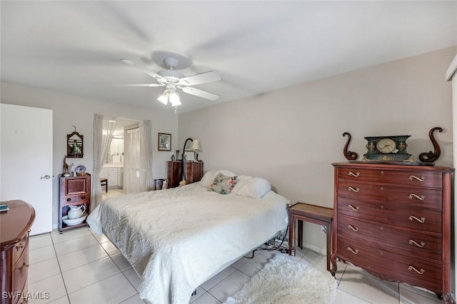 bedroom featuring light tile patterned floors, connected bathroom, and a ceiling fan