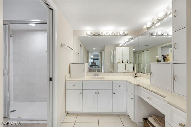 bathroom with a stall shower, vanity, and tile patterned floors