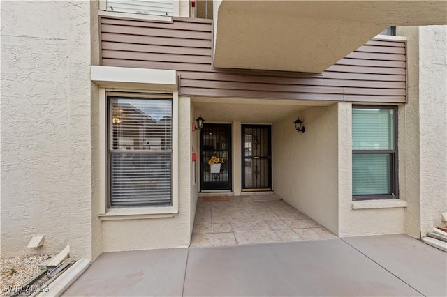 view of exterior entry with stucco siding