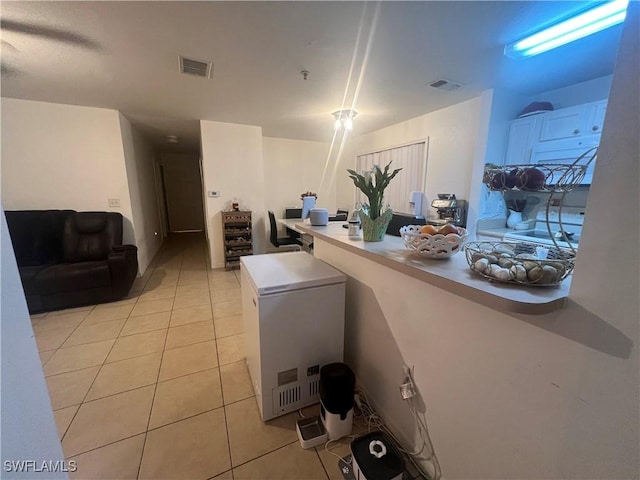 kitchen with fridge, visible vents, light countertops, and light tile patterned floors