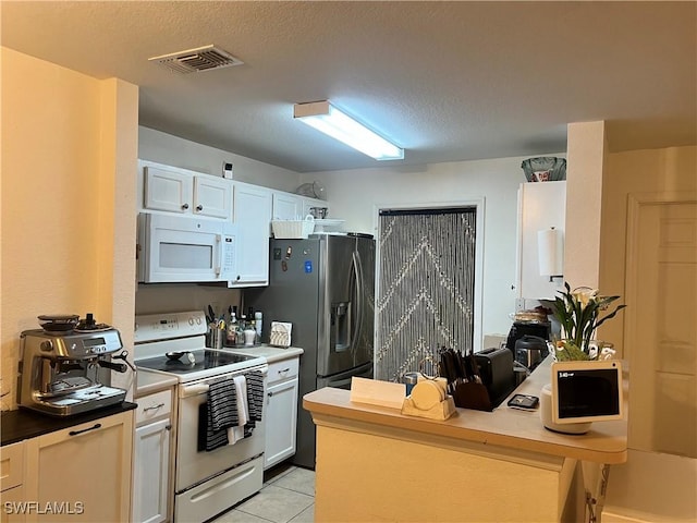 kitchen featuring white appliances, light tile patterned floors, visible vents, a peninsula, and a textured ceiling