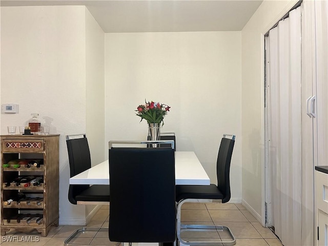 dining space with light tile patterned flooring and baseboards