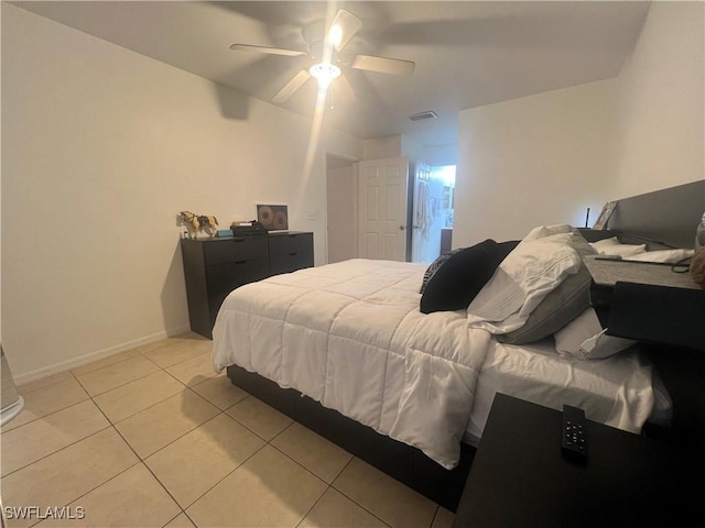 bedroom with light tile patterned floors, visible vents, a ceiling fan, and baseboards