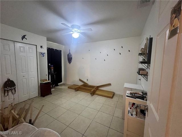 interior space featuring light tile patterned flooring, visible vents, and ceiling fan