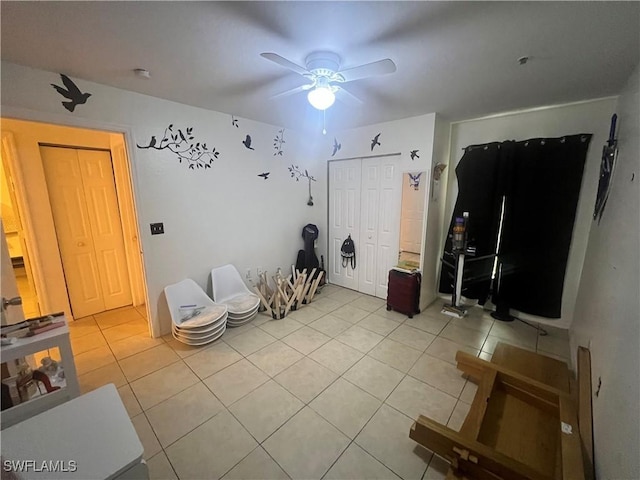 unfurnished bedroom with light tile patterned floors, a closet, and ceiling fan