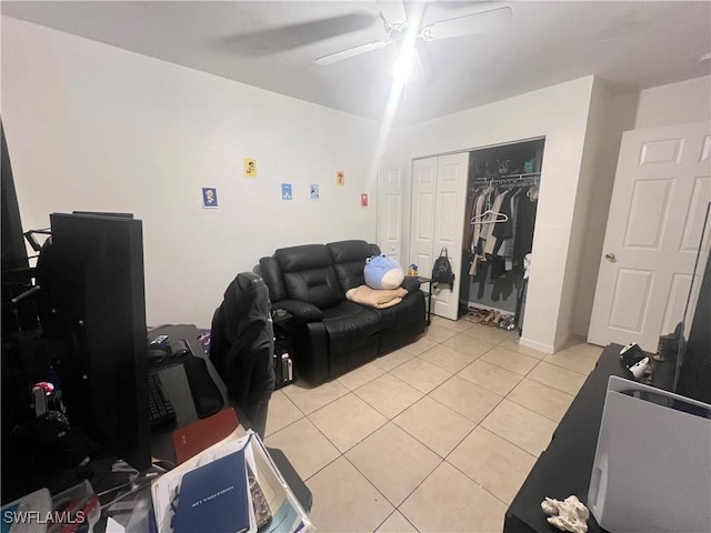 living area with light tile patterned floors and a ceiling fan