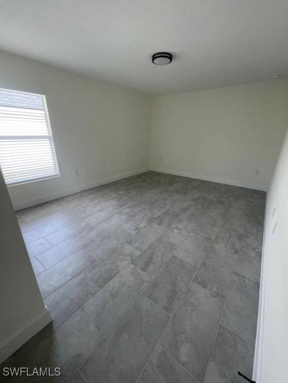 spare room with baseboards