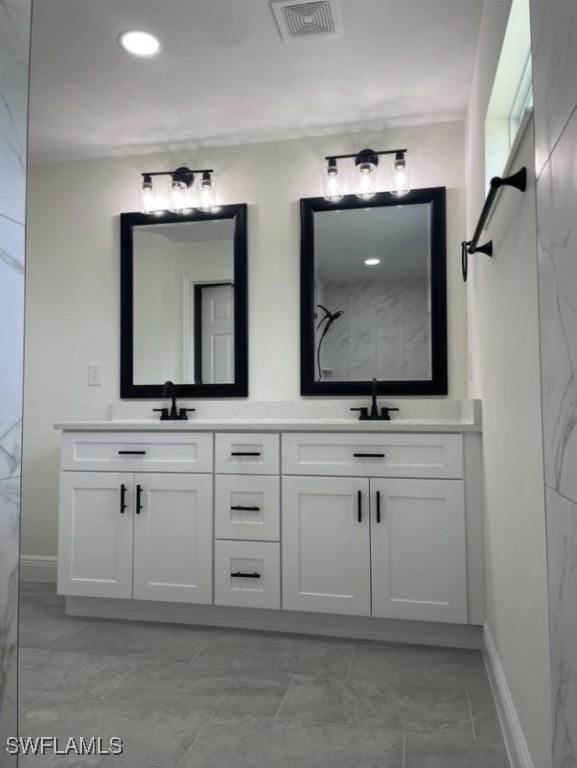 bathroom with double vanity, visible vents, walk in shower, and a sink