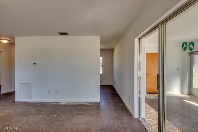 empty room with baseboards, visible vents, and unfinished concrete flooring