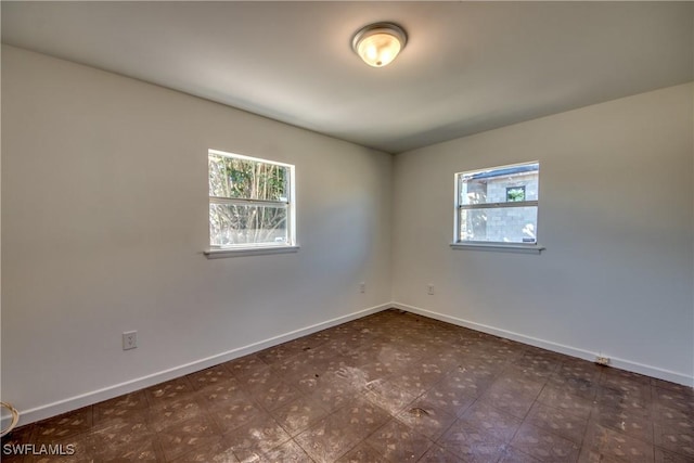 unfurnished room featuring baseboards and tile patterned floors