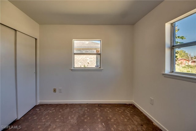 unfurnished bedroom with baseboards and a closet