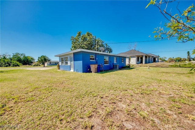 back of property with cooling unit and a lawn