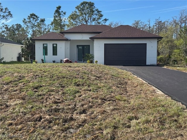 ranch-style home with aphalt driveway, french doors, roof with shingles, stucco siding, and an attached garage