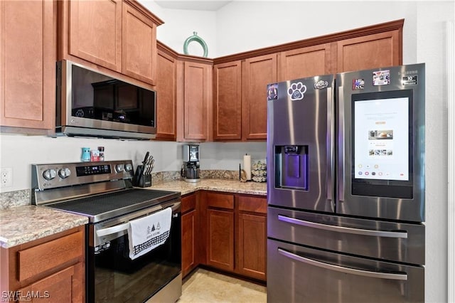 kitchen with light stone countertops, appliances with stainless steel finishes, and brown cabinetry