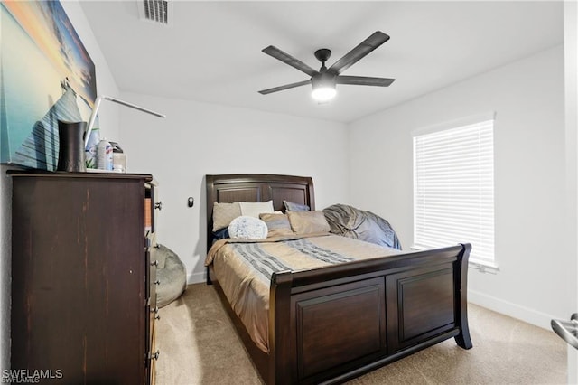 bedroom featuring light carpet, ceiling fan, visible vents, and baseboards