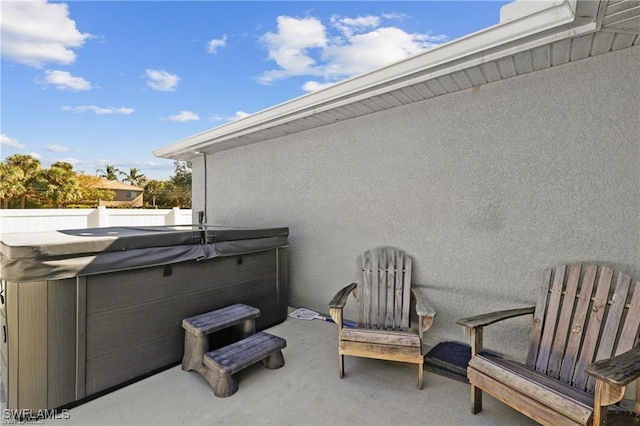 view of patio / terrace featuring fence and a hot tub