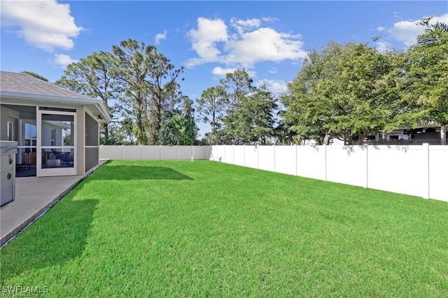 view of yard featuring a sunroom and a fenced backyard